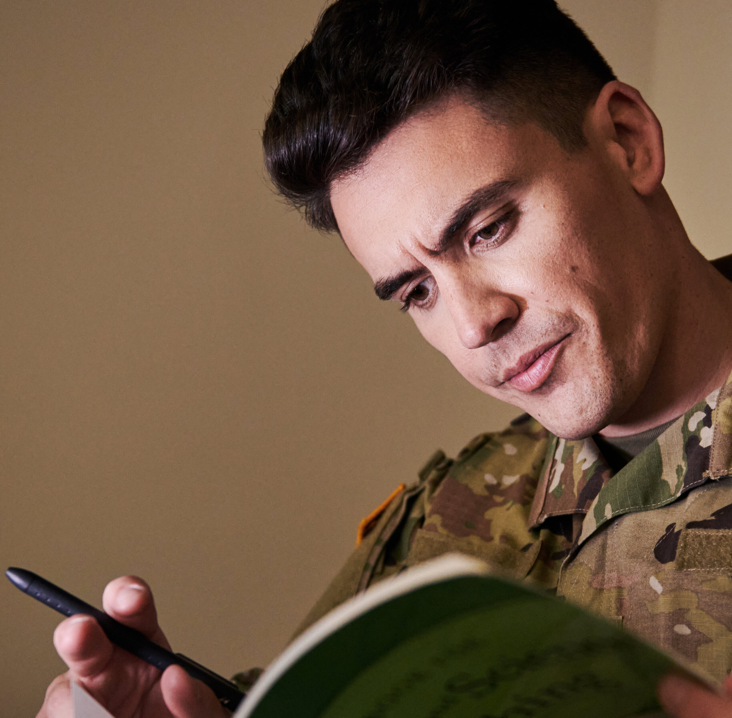 Handsome man in the service reads a book.